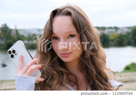 Young happy elegant busy professional African American business woman. company executive manager worker wearing suit using cell phone walking in office hall holding mobile phone Young happy elegant busy professional African American business woman. company executive manager worker wearing suit using cell phone walking in office hall holding mobile phone 112069784