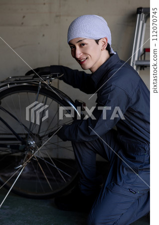 A young man wearing work clothes 112070745