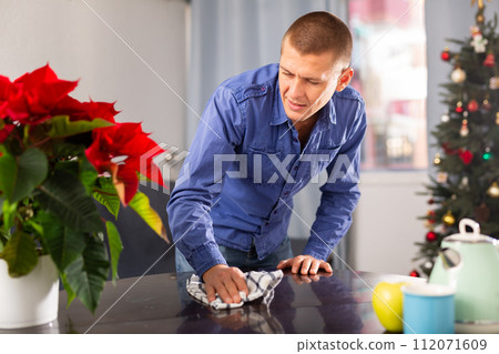 Man wipes the table before Christmas Man wipes the table before Christmas 112071609