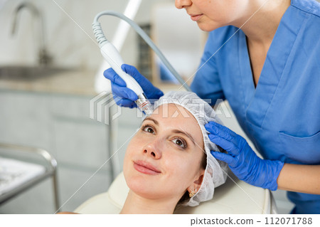 Adult woman cosmetologist doing cleansing procedure to young woman 112071788