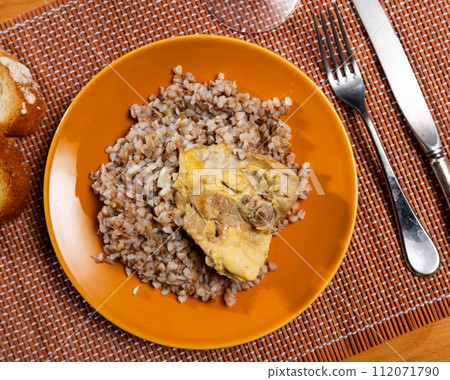 Boiled buckwheat in bowl with chicken thighs. Dinner table, healthy food concept 112071790