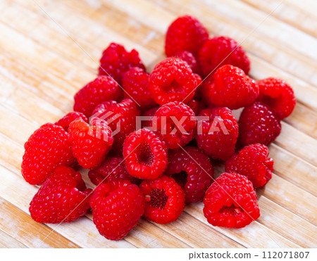 Juicy fresh raspberries served to table 112071807