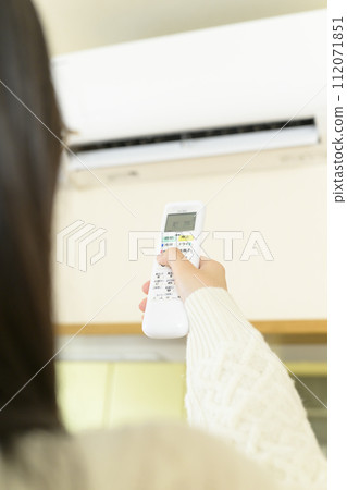 操作空調的女士（專注於遙控器） 112071851