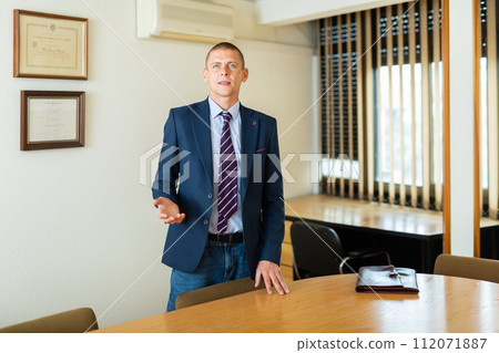 Portrait of man welcoming to modern office Portrait of man welcoming to modern office 112071887