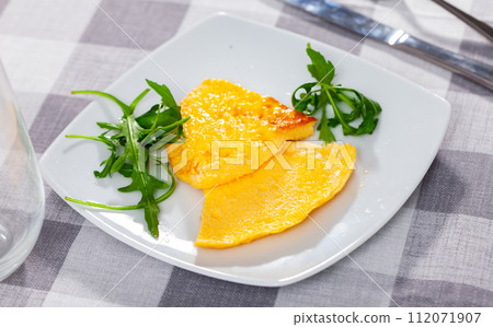Omelette served with arugula on platter 112071907