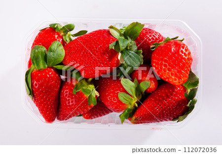 Fresh berries of red ripe strawberry on white surface closeup 112072036