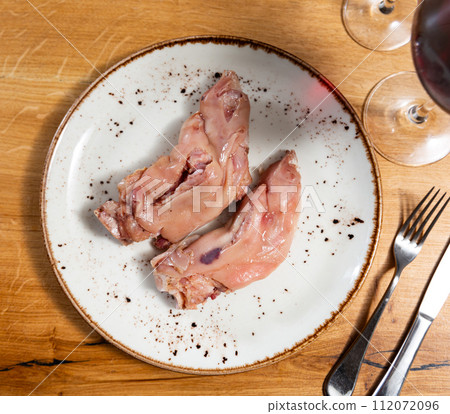 Pigs trotter served on white circular plate close up 112072096