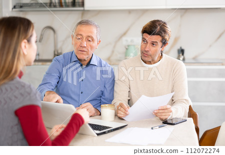 Two men discussing deal with seller in kitchen 112072274