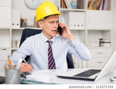 Portrait of american architect in yellow hard-hat 112072384