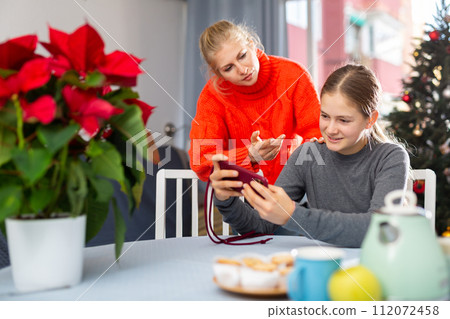 Girl sitting with phone and ignoring her mother 112072458