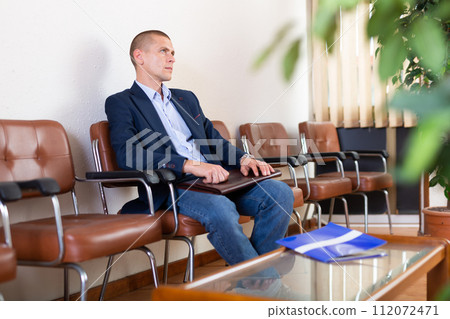 Man with briefcase waiting for job interview at office Man with briefcase waiting for job interview at office 112072471