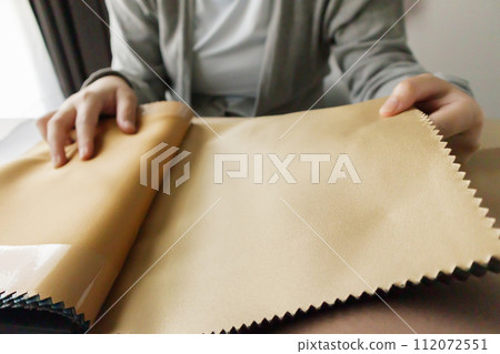 female designer with fabric color samples choosing textile for curtains 112072551
