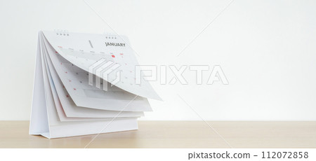 Calendar page flipping sheet on wood table background business schedule planning appointment meeting concept 112072858