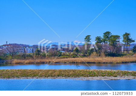 View of people rowing SUP from the Tama River over Noborito Shinmachi in Tama Ward, Kawasaki City with Mt. Fuji in the background 112073933