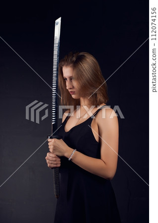 Young woman with sword in dark Young woman with sword in dark 112074156