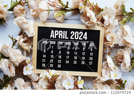 April 2024 monthly calendar with flower bouquet decoration on wooden background 112074724