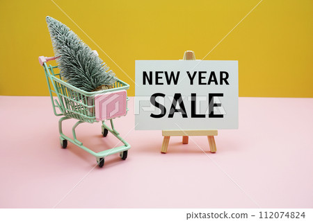 New year Sale text message with Christmas tree and trolley cart with space copy background. Christmas and New year sale concept New year Sale text message with Christmas tree and trolley cart with space copy background. Christmas and New year sale concept 112074824