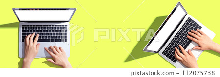 Two people working together with laptop computers 112075738