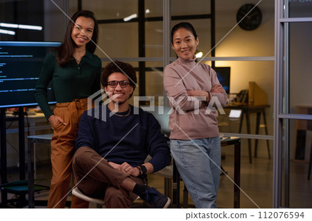 Group of young ethnically diverse developers wearing stylish casual clothes posing for camera in modern office Group of young ethnically diverse developers wearing stylish casual clothes posing for camera in modern office 112076594