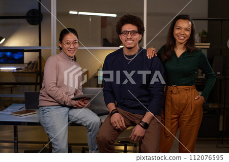 Portrait of three young ethnically diverse male and female programmers posing for camera in modern office 112076595
