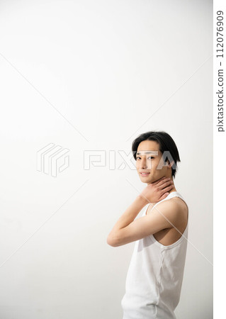 一個穿著背心的年輕人在白色背景下擺姿勢 一個穿著背心的年輕人在白色背景下擺姿勢 112076909