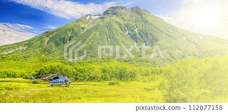 Helicopter on Khodutka Volcano. South Kamchatka Nature Park on sunlight Helicopter on Khodutka Volcano. South Kamchatka Nature Park on sunlight 112077158