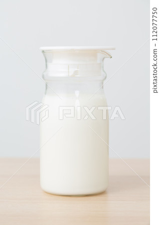 milk in a glass milk pot milk in a glass milk pot 112077750