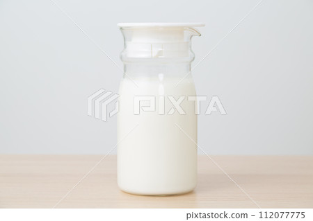 milk in a glass milk pot milk in a glass milk pot 112077775