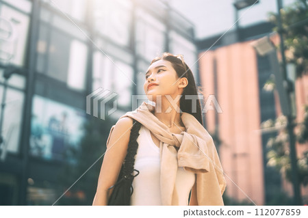 Youth asian woman looking up at outdoor urban teenager gen z lifestyles 112077859