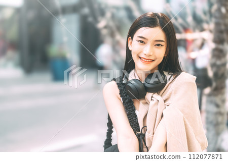 Portrait of youth asian woman teenager gen z looking at camera wearing headphone 112077871