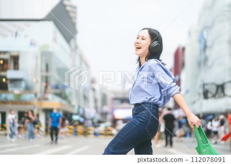 Young adult asian woman wear wireless headphone urban people lifestyles with positive self love 112078091