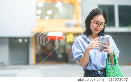 Business asian woman using smartphone city lifestyles with casual fashion positive look Business asian woman using smartphone city lifestyles with casual fashion positive look 112078097