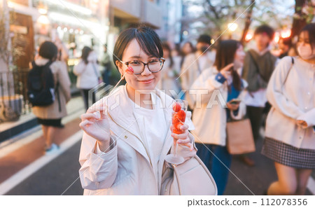 Asian woman eating popular menu in sakura festival Nakameguro Tokyo city at night street travel Asian woman eating popular menu in sakura festival Nakameguro Tokyo city at night street travel 112078356