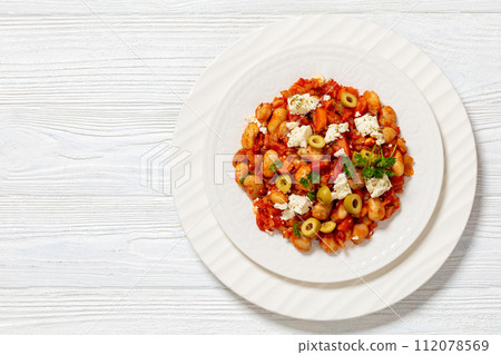 greek giant baked beans with feta, olives on plate 112078569