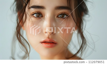 Illustration of a close-up photo of a beautiful young woman's face with good skin posing as a model selling skin care cosmetics. Can be used as an idea for models to pose for advertising shoots. 112079051