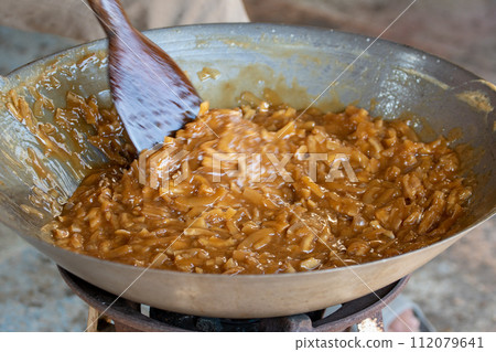 thin coconut flakes fried in sugar syrup thin coconut flakes fried in sugar syrup 112079641