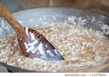 thin coconut flakes fried in sugar syrup 112079644