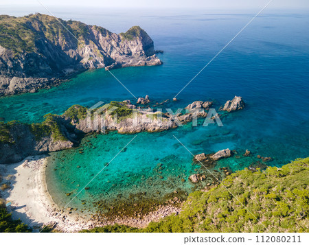 Aerial drone photography of Nakanoura Beach, Kamibikiura, and Kamibiki Observation Deck, where the blue sea and green forest are beautiful. Niijima, Izu Islands, Tokyo 112080211