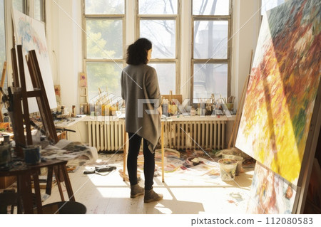 Woman Standing in Front of Painting on Easel at Art Studio Woman Standing in Front of Painting on Easel at Art Studio 112080583