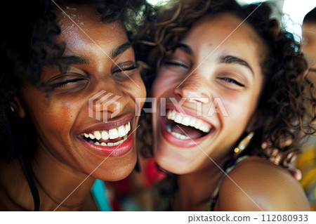 Two Young Women Laughing and Smiling Together 112080933