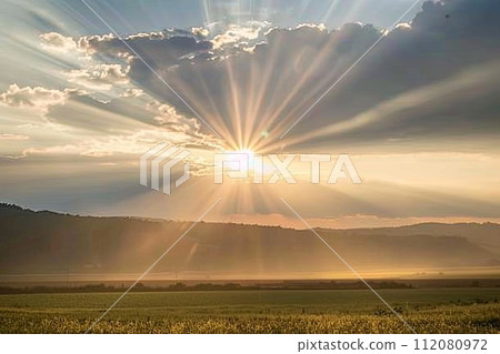 Sun Shining Through Clouds Over Field Sun Shining Through Clouds Over Field 112080972