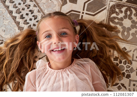 Girl with blue eyes lies on floor dreaming about future 112081307