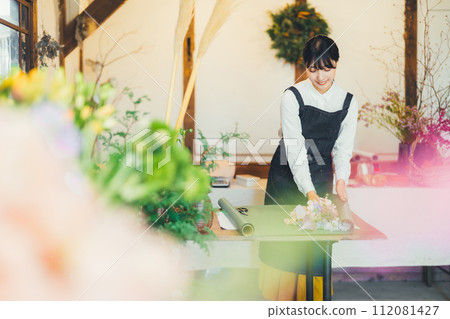 A woman working in a flower shop A woman working in a flower shop 112081427