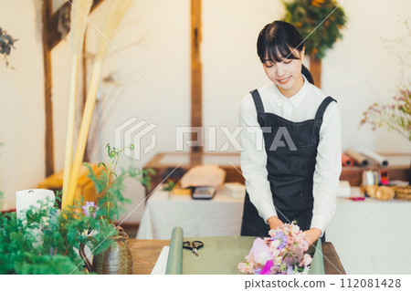 A woman working in a flower shop 112081428