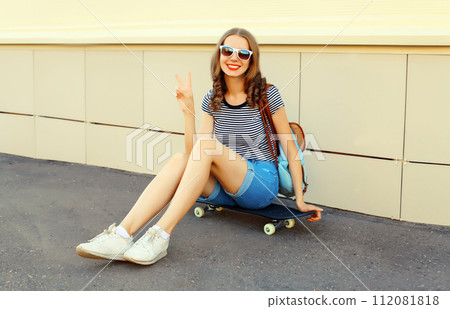 Portrait of cheerful young woman with skateboard in the city Portrait of cheerful young woman with skateboard in the city 112081818