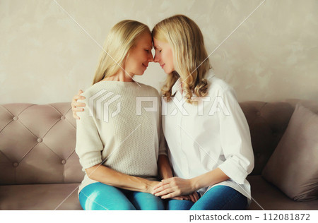happy smiling middle aged mother and adult daughter looking at each other together at home 112081872