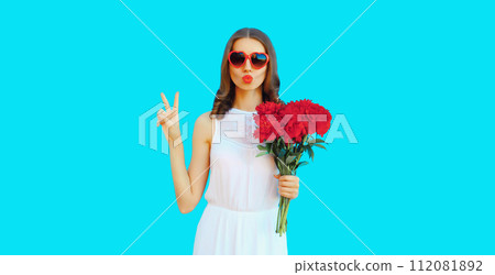 Portrait of beautiful woman with bouquet of red rose flowers in heart shaped sunglasses 112081892