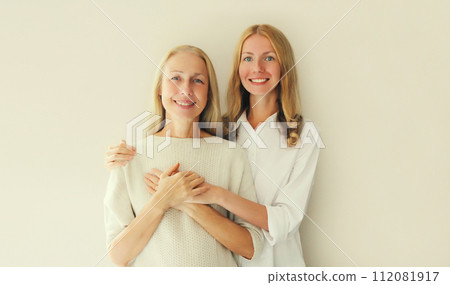Portrait of happy smiling caucasian middle aged mother or sister and adult daughter together 112081917