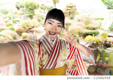 一個穿著日式服裝的女人在自拍 112082416