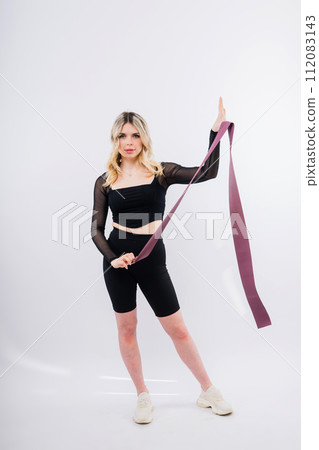 Young woman workout with resistance band on white background. Strength and motivation. Young woman workout with resistance band on white background. Strength and motivation. 112083143